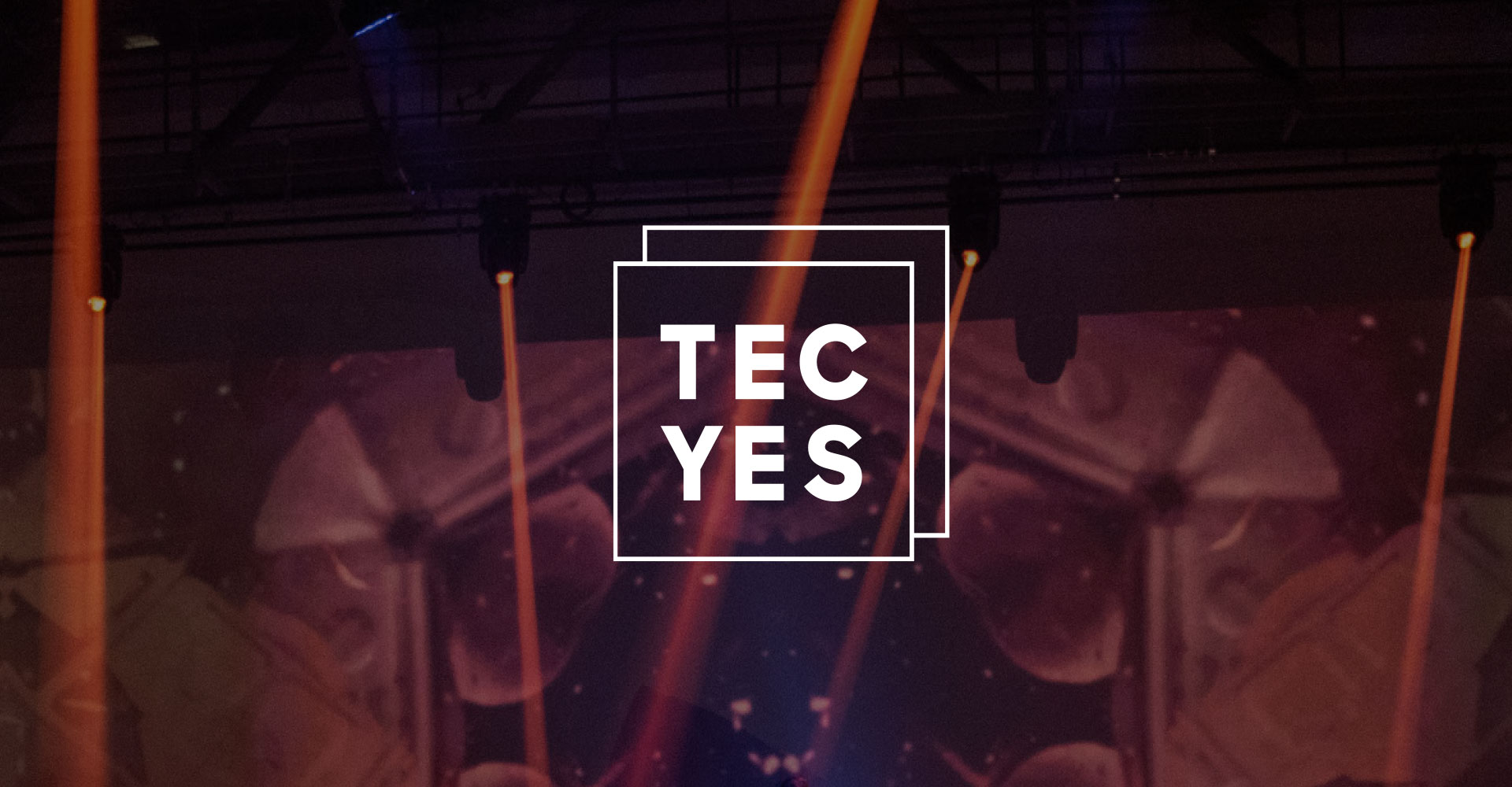 Tec Yes logo — two overlapping outlined squares framing the stacked wordmark 'TEC YES' — set against a blurred concert stage lit with orange beams.