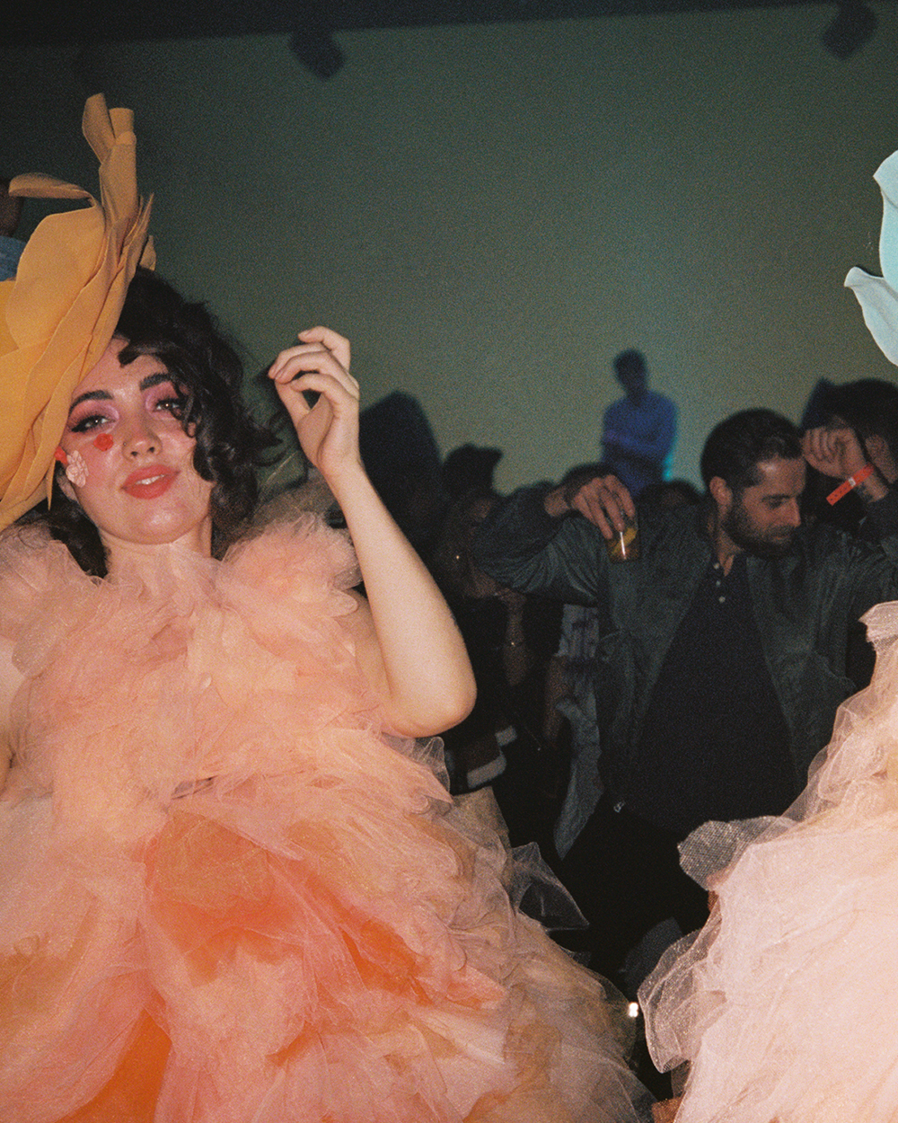 A guest in an elaborate peach tulle costume and feathered headpiece at the Mack Sennett Grammy afterparty.